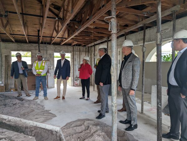 Group of professionals inspecting a building under construction indoors.