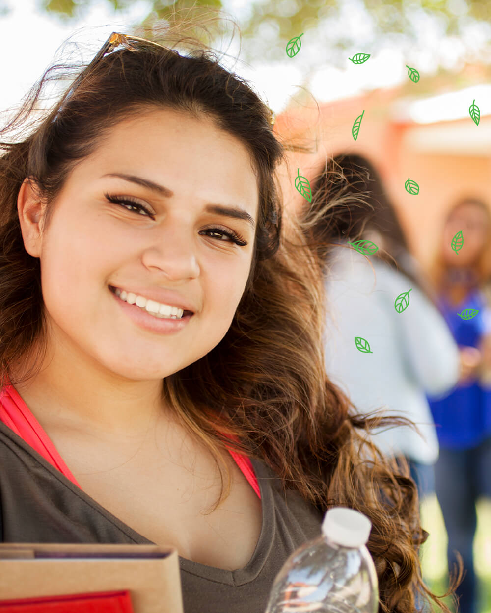 Smiling teenage girl outdoors with green leaves and blurred background.